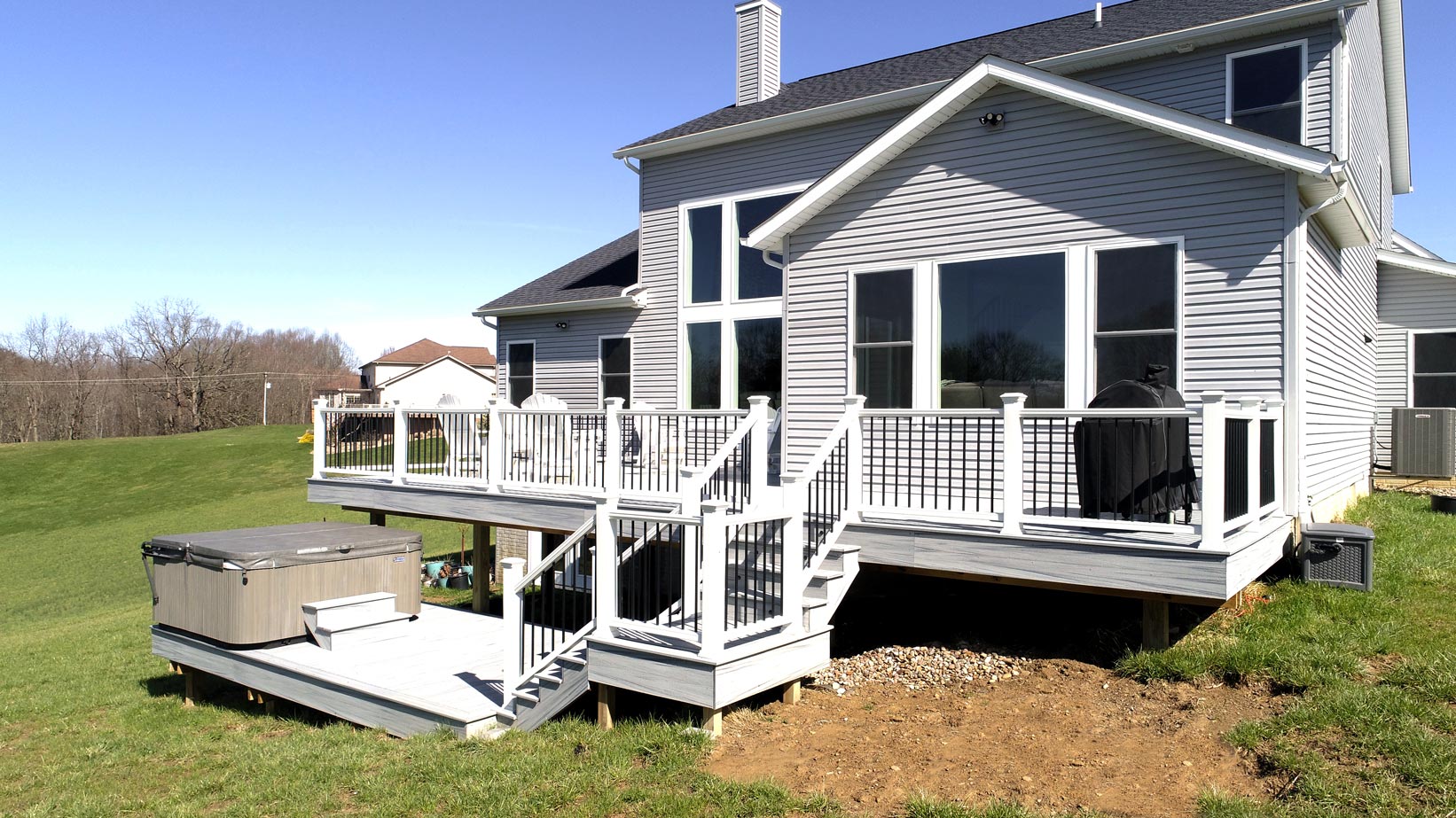 Grey backyard deck with white vinyl railing