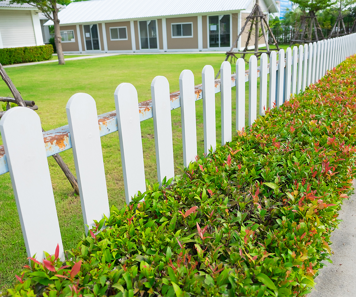 fence-contractor-sugarcreek-Pet Safety Worn white picket fence needing repair by fence contractor Sugarcre