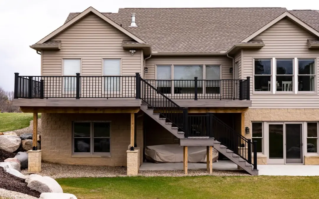 Elevated second-story deck with black railing, stairs, and space underneath for a patio